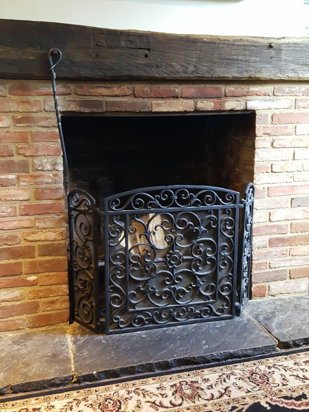 A fireplace with an iron screen